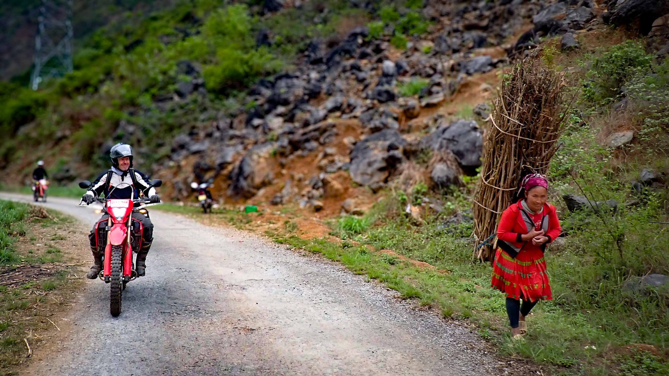 Dirt bike rider on Honda CRF 300L crossing a mountain bridge on the Ha Giang Off-Road Border Tour